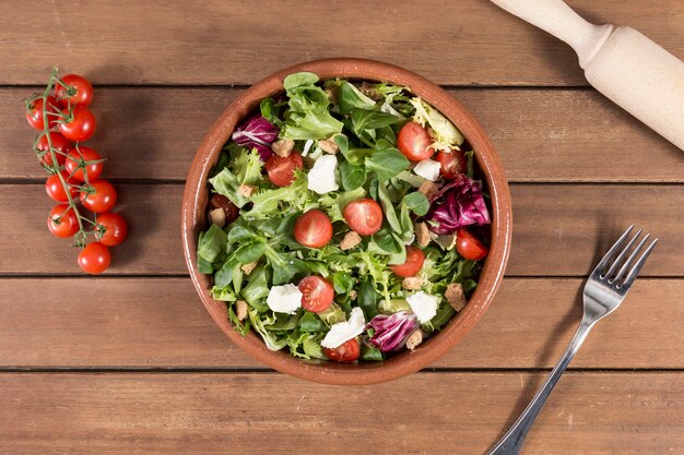 Vista superior de superficie de madera con ensalada deliciosa