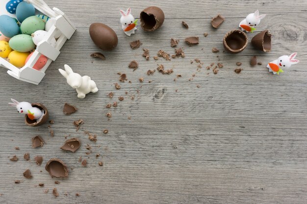 Vista superior de superficie de madera con huevos de pascua y conejos