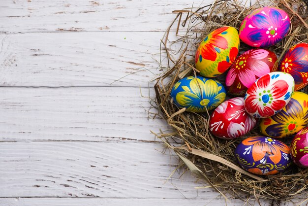 Vista superior de superficie de madera con huevos de pascua pintados