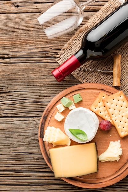 Vista superior surtido de quesos gourmet con vino y copa