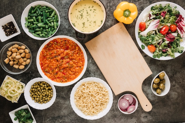 Foto gratuita vista superior de la tabla de cortar con cebolla y ensalada.