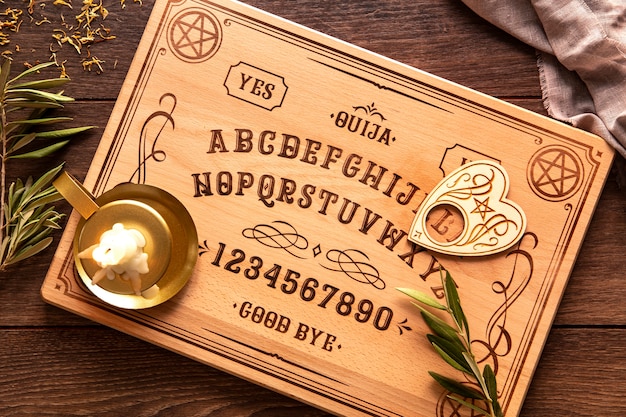 Foto gratuita vista superior del tablero de ouija y vela