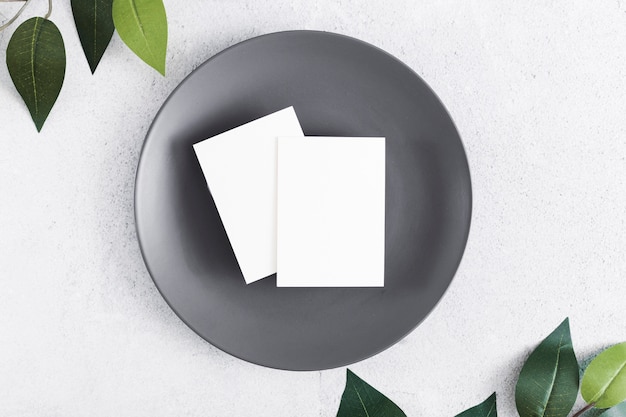 Foto gratuita vista superior de tarjetas en blanco en un plato