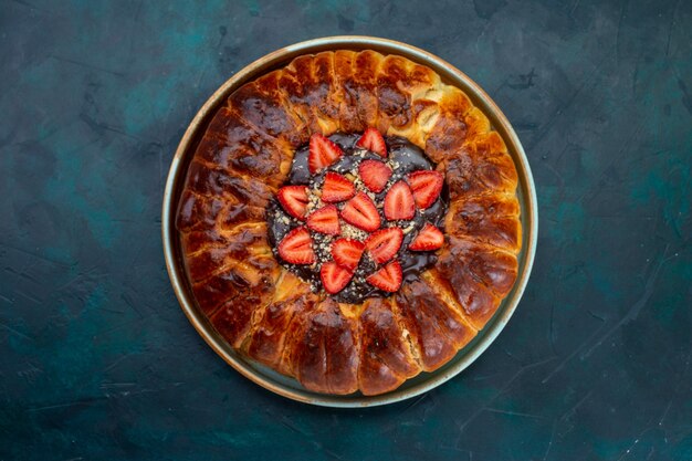 Vista superior de la tarta de fresa con mermelada y fresas rojas frescas en la superficie azul