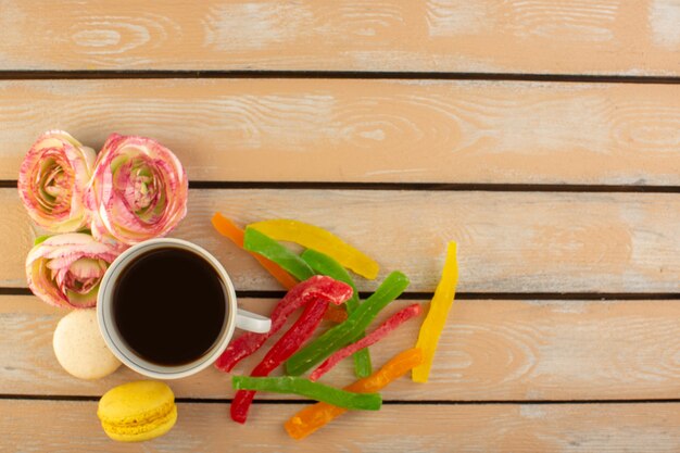 Vista superior de una taza de café caliente y fuerte con macarons franceses y mermelada en el escritorio rústico de color crema beber café foto azúcar galleta dulce