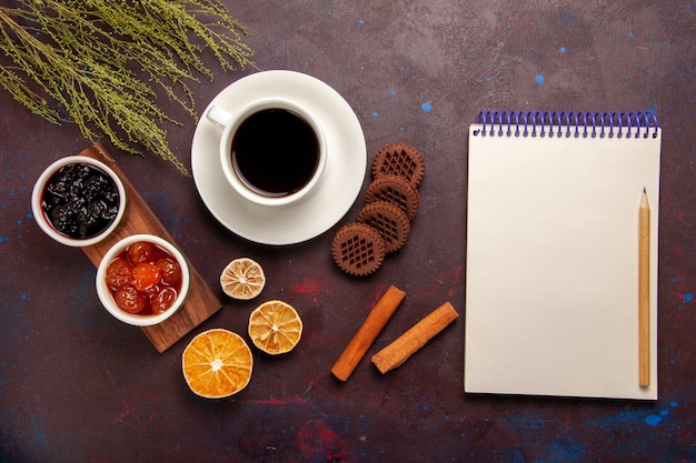 Vista superior de la taza de café con diferentes mermeladas y galletas de chocolate en el escritorio oscuro mermelada de frutas dulce mermelada