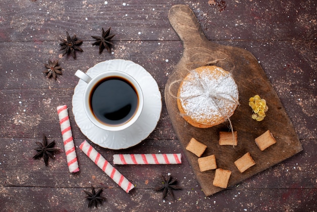 Vista superior de la taza de café fuerte y caliente junto con galletas y bizcochos en el escritorio de madera marrón, pastel de frutas, bizcocho de café dulce