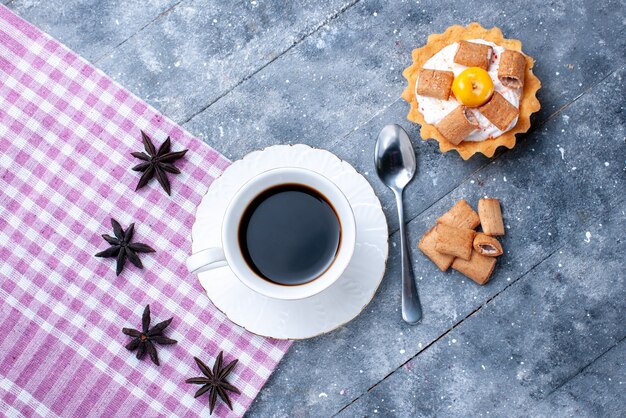 Foto gratuita vista superior de la taza de café con galletas formadas de almohada y pastel cremoso en masa dulce de galletas de galletas de café brillante