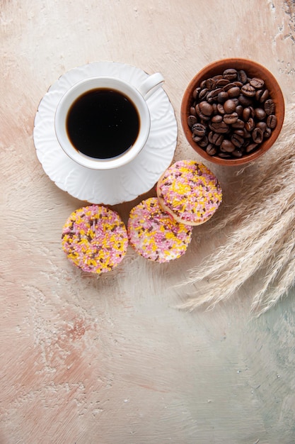 Foto gratuita vista superior de la taza de café con galletas y semillas de café frescas en una superficie clara