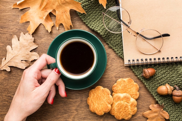 Vista superior de la taza de café con hojas de otoño y cuaderno