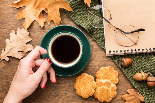 Vista superior de la taza de café con hojas de otoño y cuaderno