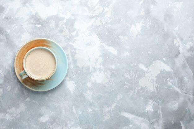 Vista superior de la taza de café con leche dentro de la taza en el escritorio blanco beber café leche color del escritorio