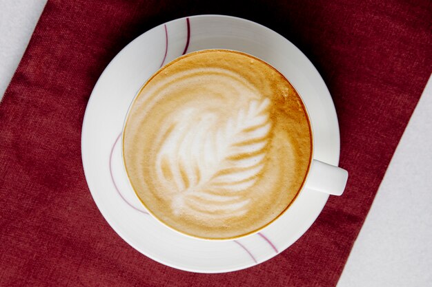 Vista superior de una taza de café con leche en la mesa