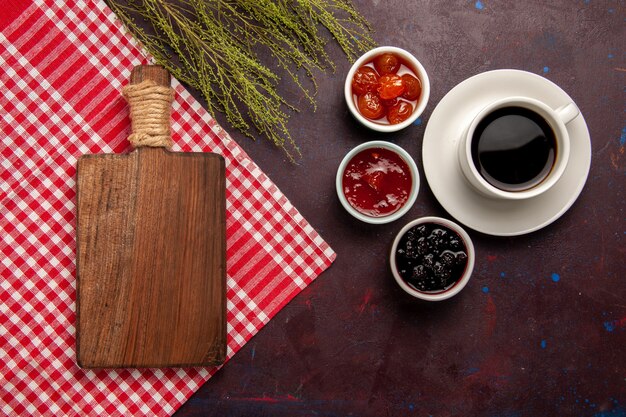 Vista superior de la taza de café con mermeladas de frutas sobre el fondo oscuro mermelada de frutas café dulce