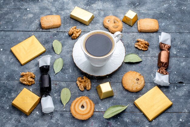 Vista superior de la taza de café con nueces galletas en gris, hornear dulce galleta galleta