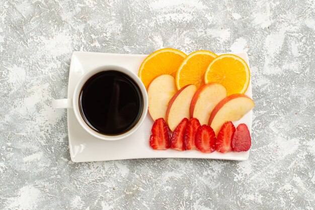 Vista superior de la taza de café con rodajas de manzanas, naranjas y fresas sobre fondo blanco fruta madura fresca suave