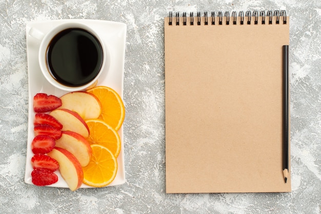 Vista superior de la taza de café con rodajas de manzanas, naranjas y fresas sobre fondo blanco frutas maduras suaves frescas