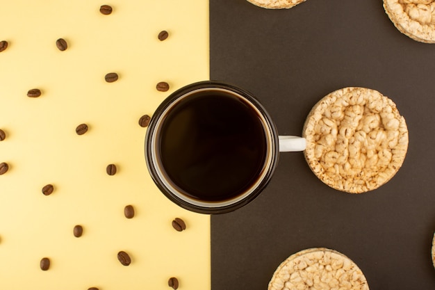 Foto gratuita vista superior de una taza de café con semillas de café marrón y galletas