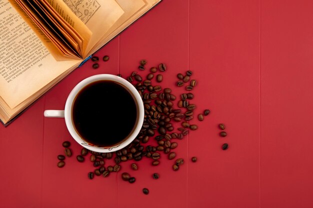 Vista superior de una taza de delicioso café con granos de café aislado sobre un fondo de res con espacio de copia