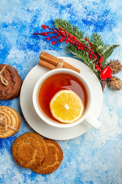 Vista superior de la taza de galletas de té atadas con una cuerda sobre fondo azul.