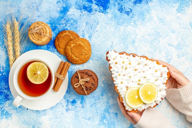 Vista superior de una taza de galletas de té en el espacio libre de la mesa azul