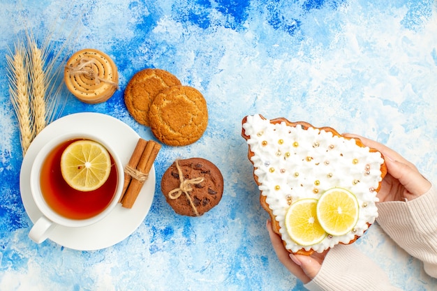 Vista superior de una taza de galletas de té en el espacio libre de la mesa azul