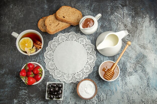 Vista superior de la taza de té con aceitunas y frutas en la superficie oscura de la comida del desayuno de la mañana