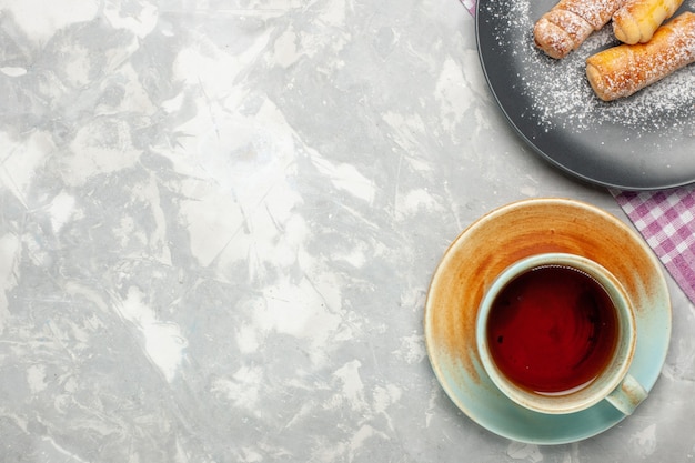 Vista superior de la taza de té con bagels sobre superficie blanca