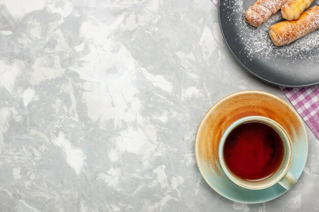 Vista superior de la taza de té con bagels sobre superficie blanca