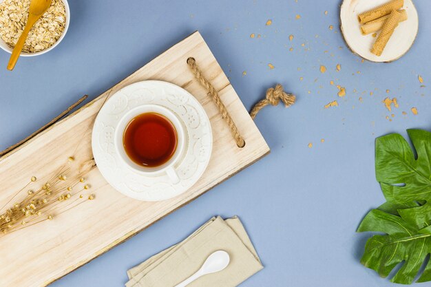 Vista superior taza de té en bandeja de madera