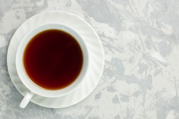 Vista superior de la taza de té bebida caliente en el escritorio blanco claro