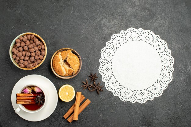 Vista superior de la taza de té con canela en la ceremonia de bebida de té de superficie gris oscuro dulce