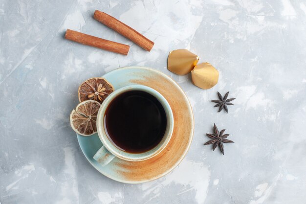 Vista superior de la taza de té con canela en el escritorio blanco té color caramelo desayuno