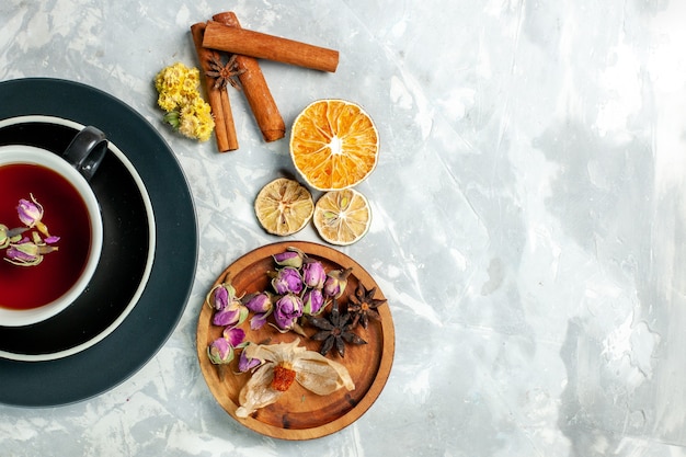 Vista superior de la taza de té con canela y flores en la pared blanca flor de bebida dulce té