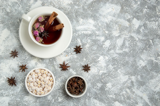 Vista superior de la taza de té con caramelos sobre fondo blanco bebida de té desayuno de azúcar dulce caliente