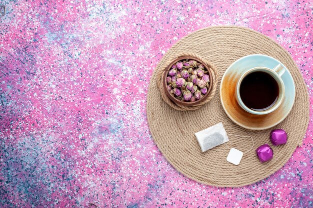 Foto gratuita vista superior de la taza de té con caramelos sobre fondo rosa.