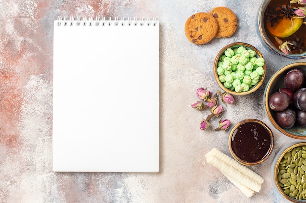 Vista superior de una taza de té con ciruelas y dulces.