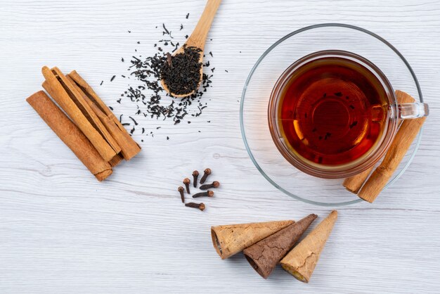 Vista superior de una taza de té con cuernos té fresco y canela en blanco, té de postre de desayuno