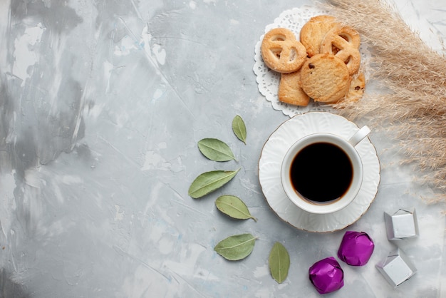 Vista superior de la taza de té con deliciosas galletas dulces de chocolate en piso ligero galleta galleta té dulce azúcar