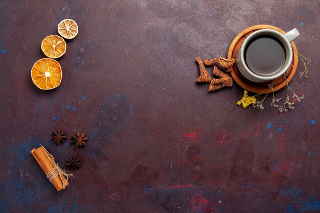 Vista superior de la taza de té dentro de la placa y la taza sobre fondo oscuro bebida de té dulce de fotografía en color