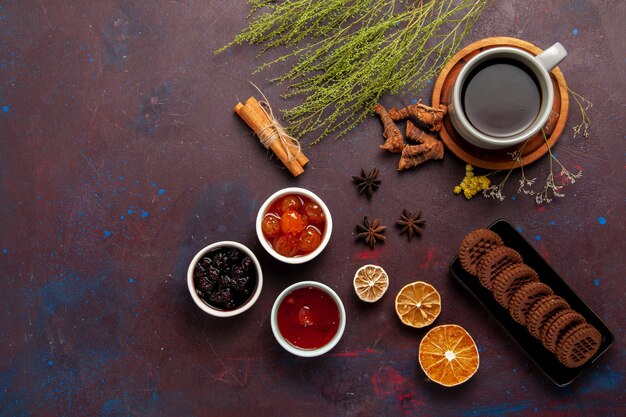 Vista superior de la taza de té dentro de la placa y la taza sobre fondo oscuro bebida de té dulce de fotografía en color