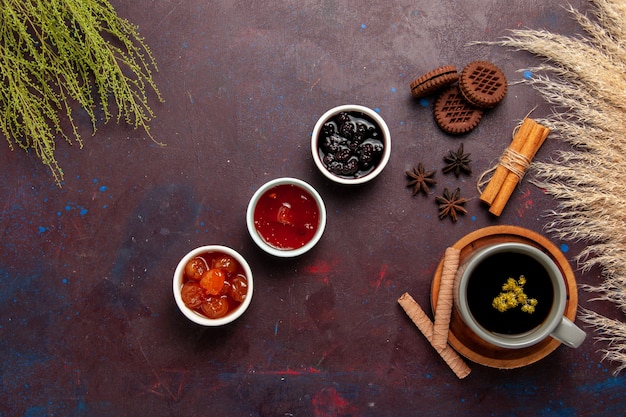 Vista superior de la taza de té dentro de la placa y la taza sobre fondo oscuro bebida de té dulce de fotografía en color