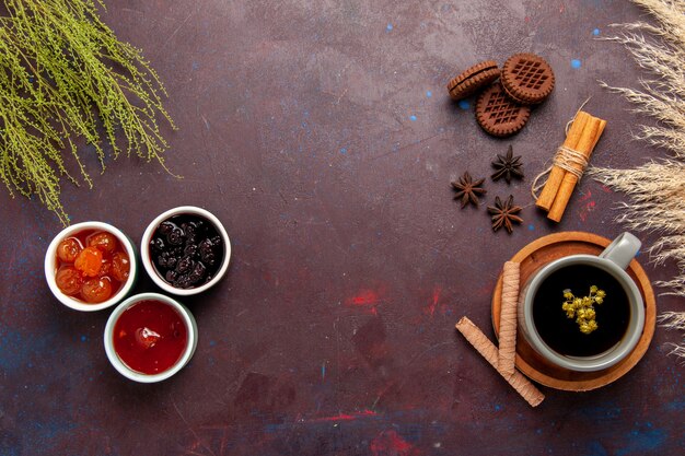 Vista superior de la taza de té dentro de la placa y la taza sobre fondo oscuro bebida de té dulce de fotografía en color