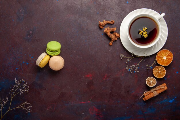 Vista superior de la taza de té dentro de la placa y la taza sobre fondo oscuro bebida de té dulce de fotografía en color