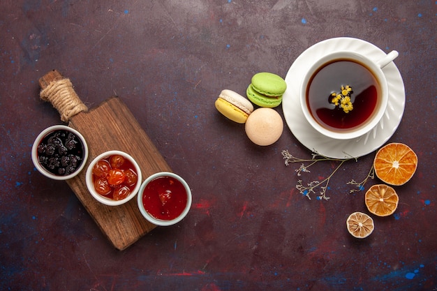 Vista superior de la taza de té dentro de la placa y la taza sobre fondo oscuro bebida de té dulce de fotografía en color