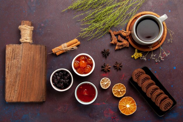 Vista superior de la taza de té dentro de la placa y la taza en la superficie oscura bebida de té dulce de fotografía en color