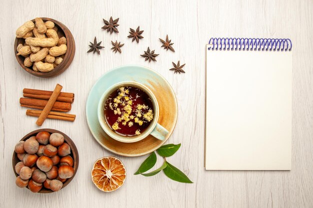 Vista superior de la taza de té con diferentes frutos secos en la tuerca de ceremonia de fruta de té de color de superficie blanca