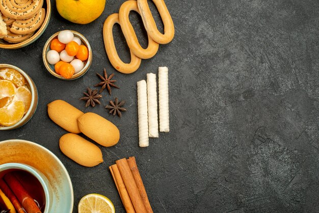 Vista superior de la taza de té con dulces, galletas y frutas en la mesa gris galleta dulce de té