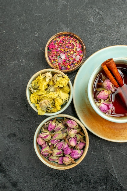 Vista superior de la taza de té con flores en la ceremonia de color de bebida de té de fondo gris oscuro