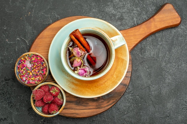 Vista superior de la taza de té con flores en la ceremonia de color de bebida de té de fondo gris oscuro